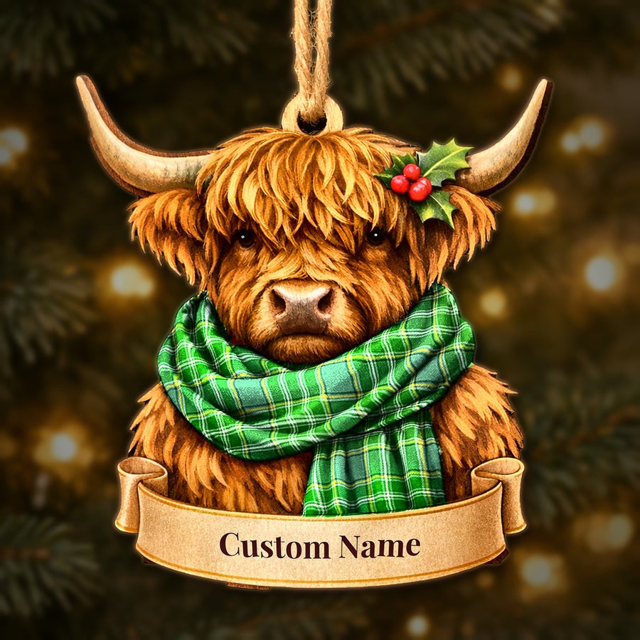 Wooden Highland cow Christmas ornament wearing a Currie tartan scarf, with a ribbon banner for a custom name
