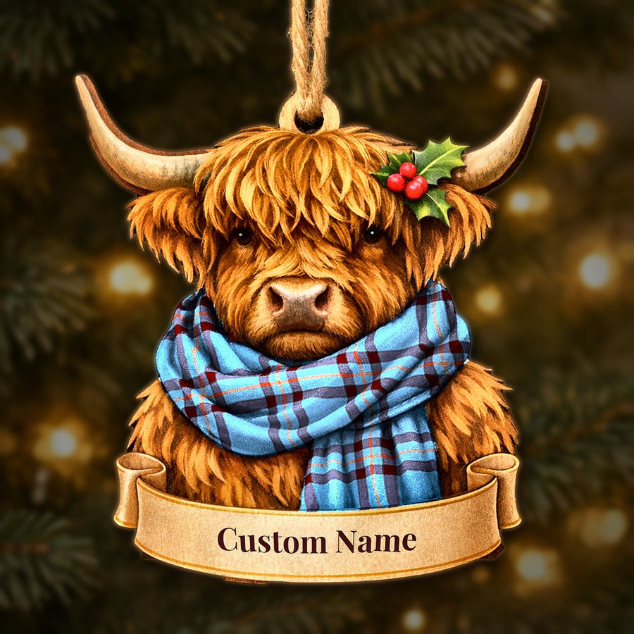Wooden Highland cow Christmas ornament wearing a Elliot Ancient tartan scarf, with a ribbon banner for a custom name