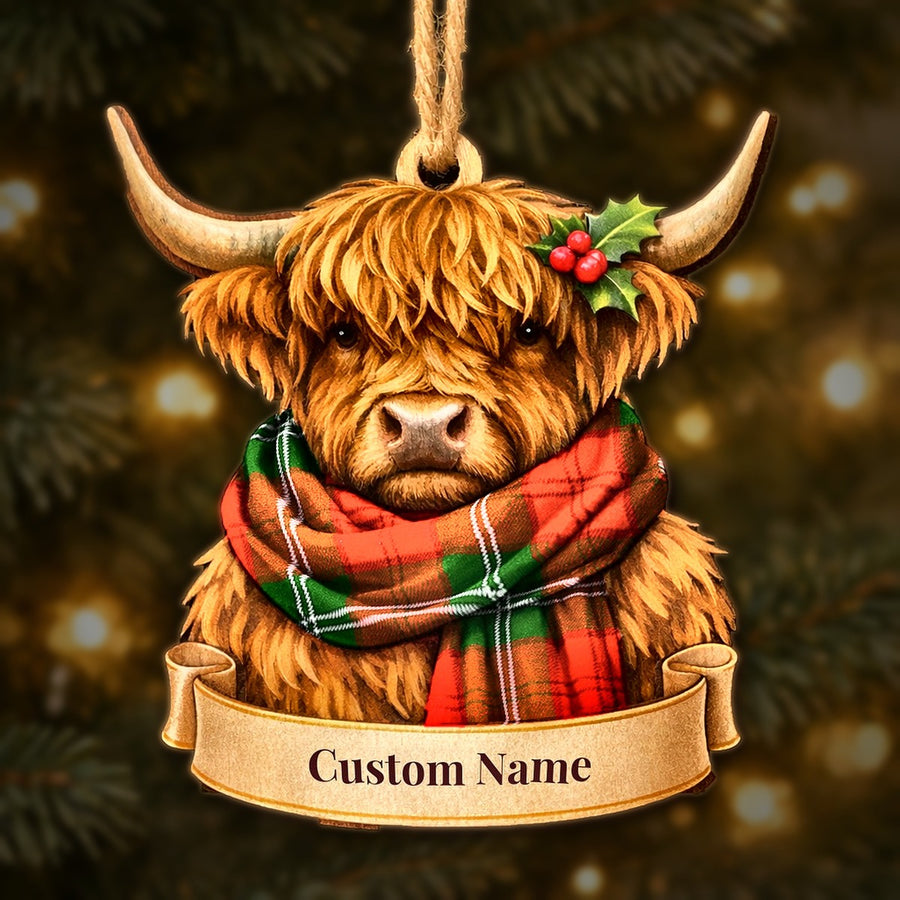 Wooden Highland cow Christmas ornament wearing a Lennox Modern tartan scarf, with a ribbon banner for a custom name