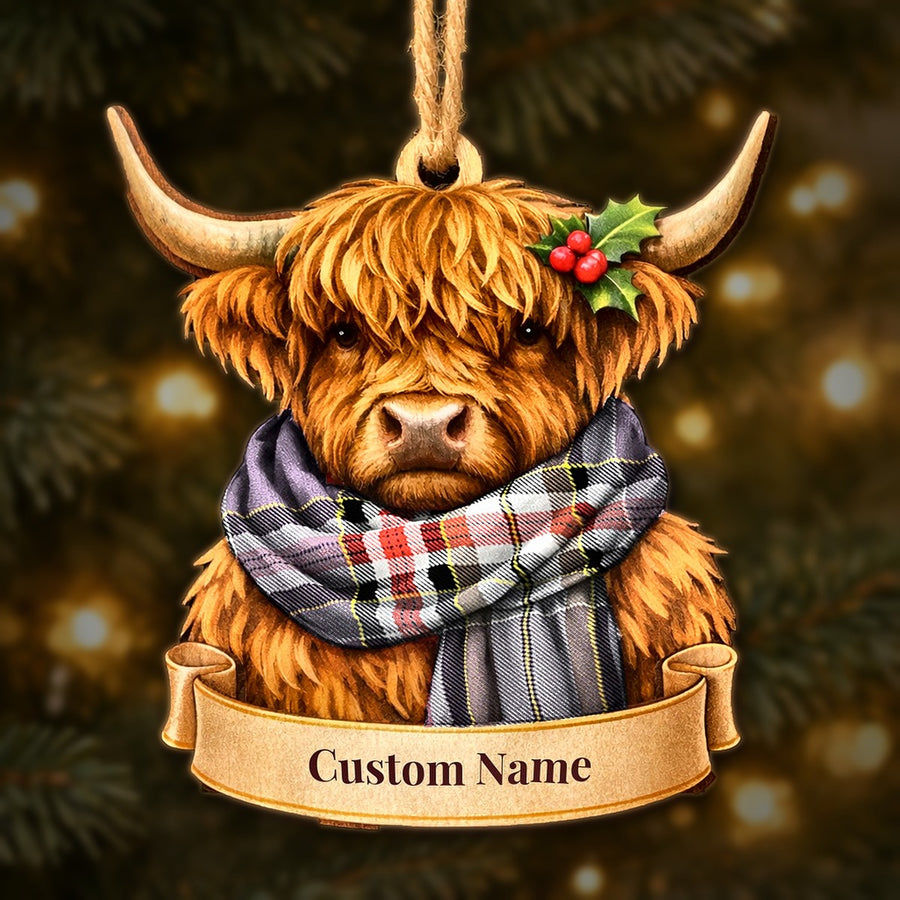 Wooden Highland cow Christmas ornament wearing a Lockwood tartan scarf, with a ribbon banner for a custom name