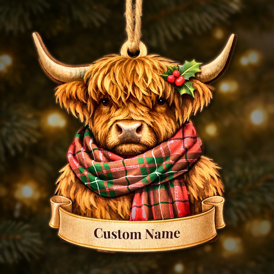 Wooden Highland cow Christmas ornament wearing a MacAulay Modern tartan scarf, with a ribbon banner for a custom name