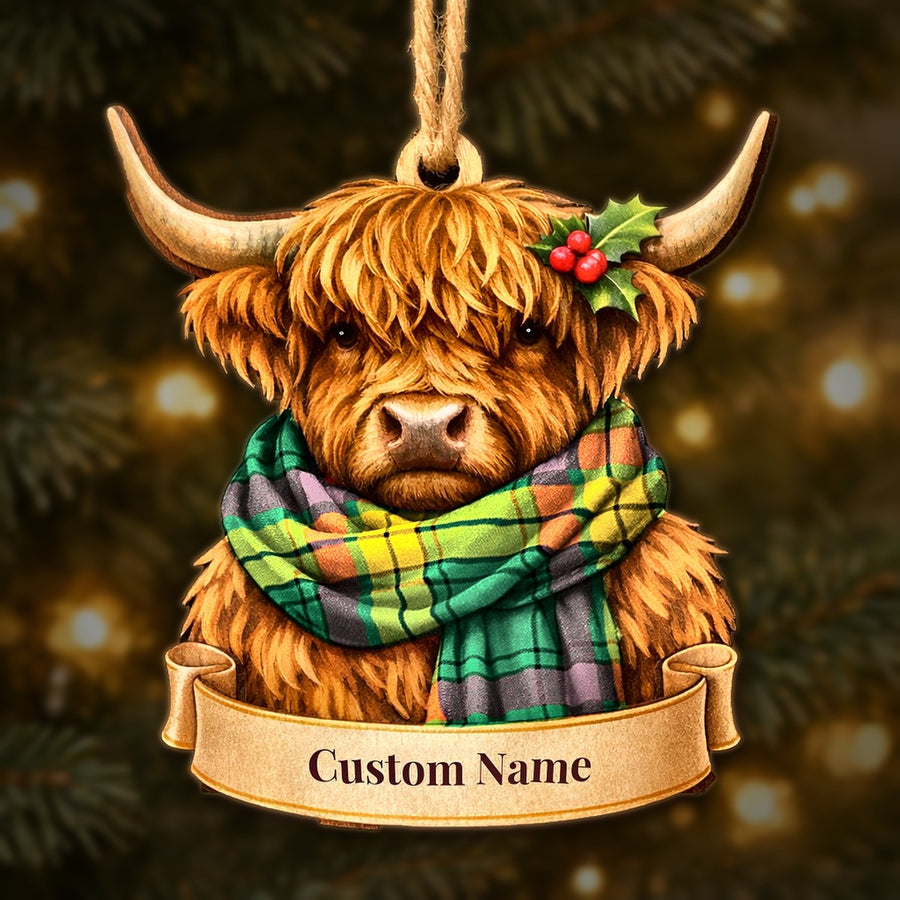 Wooden Highland cow Christmas ornament wearing a MacMillan Old Ancient tartan scarf, with a ribbon banner for a custom name