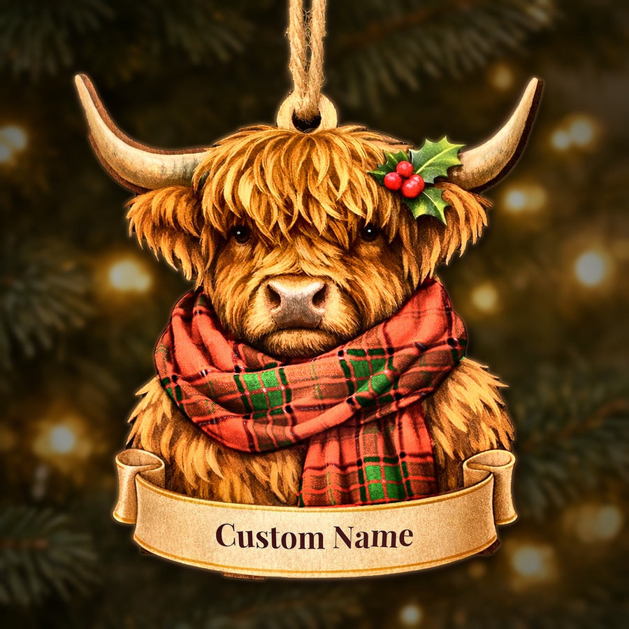Wooden Highland cow Christmas ornament wearing a Maxtone tartan scarf, with a ribbon banner for a custom name