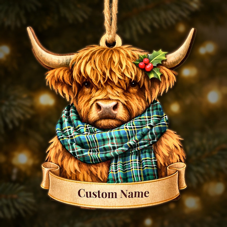 Wooden Highland cow Christmas ornament wearing a Scott Green Ancient tartan scarf, with a ribbon banner for a custom name