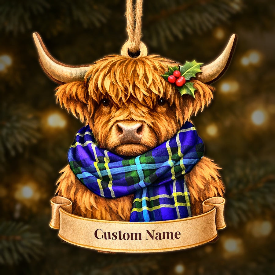 Wooden Highland cow Christmas ornament wearing a Weir Modern tartan scarf, with a ribbon banner for a custom name