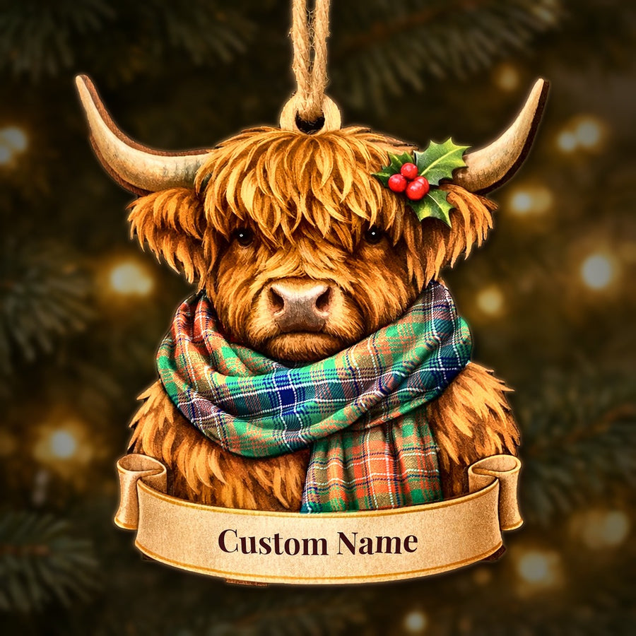 Wooden Highland cow Christmas ornament wearing a Wilson Ancient tartan scarf, with a ribbon banner for a custom name