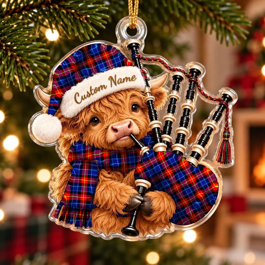 Acrylic Highland cow calf ornament playing the bagpipes, in a Anstruther tartan Santa hat, scarf and pipe bag, with a custom name on the hat