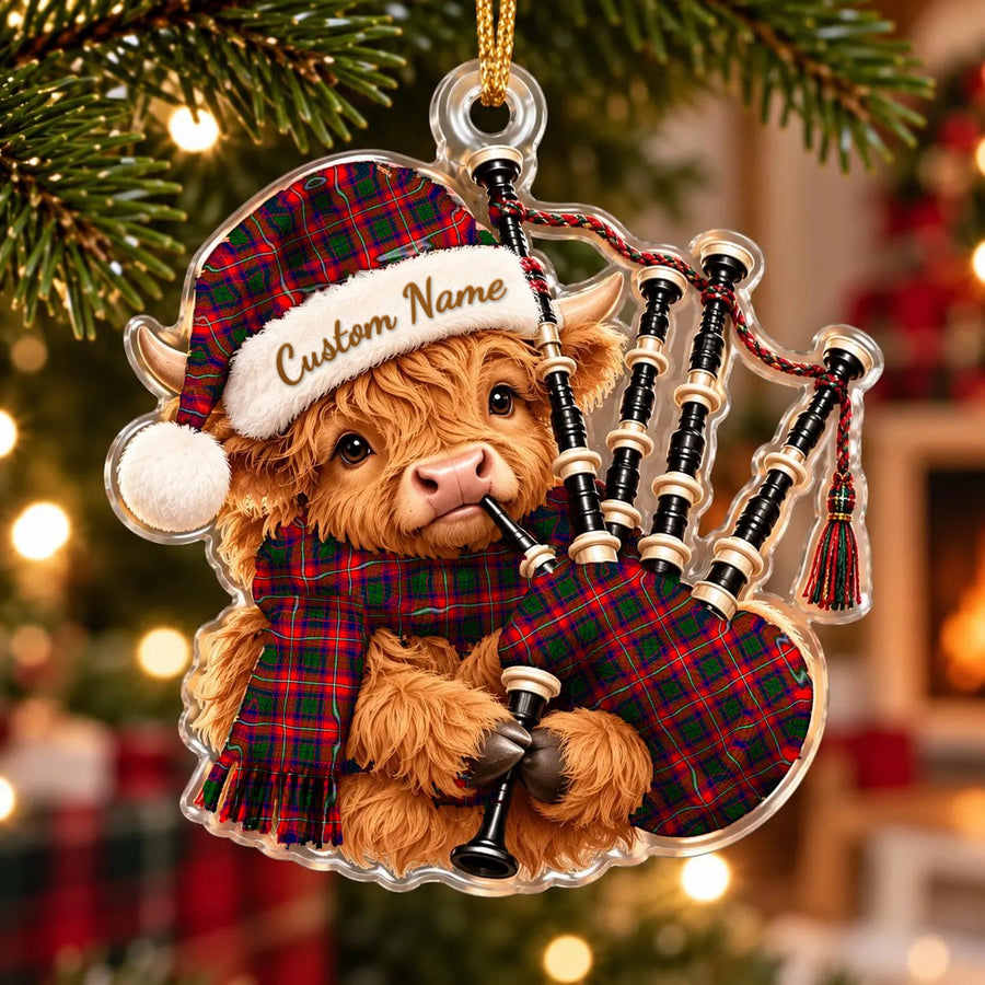 Acrylic Highland cow calf ornament playing the bagpipes, in a Belshes tartan Santa hat, scarf and pipe bag, with a custom name on the hat