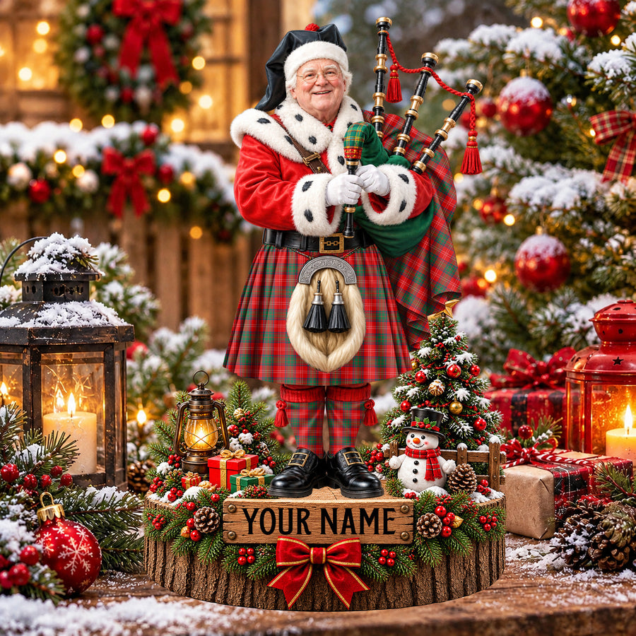 Personalized Christmas piper plaque in the Chisholm Modern tartan, standing on a snowy log base with a name plaque