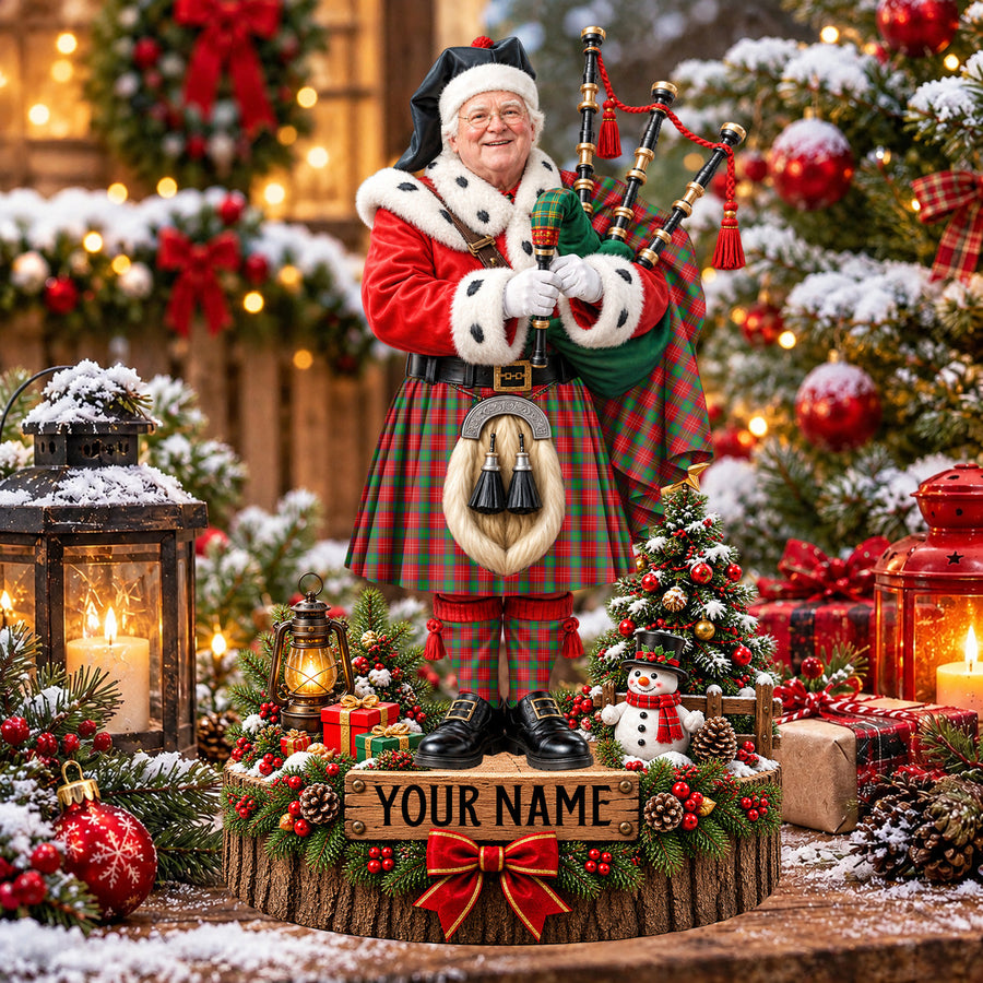 Personalized Christmas piper plaque in the Chisholm tartan, standing on a snowy log base with a name plaque