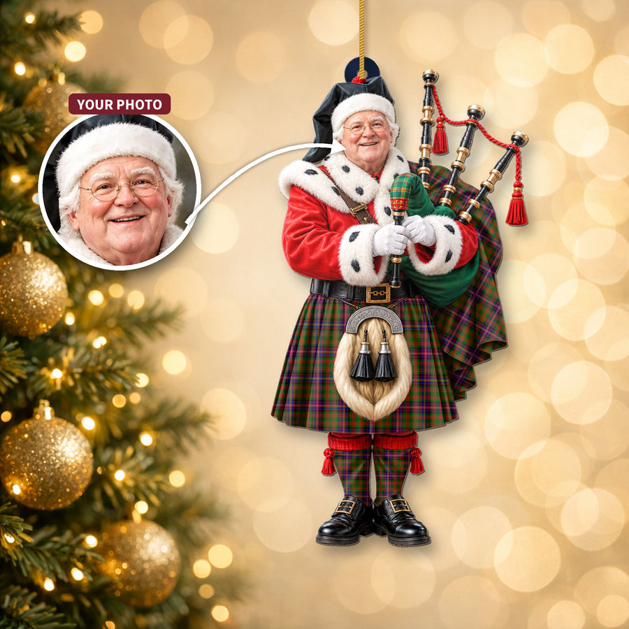 Christmas piper ornament in the Cochrane Modern tartan hanging on a Christmas tree, with the customer photo used for the face