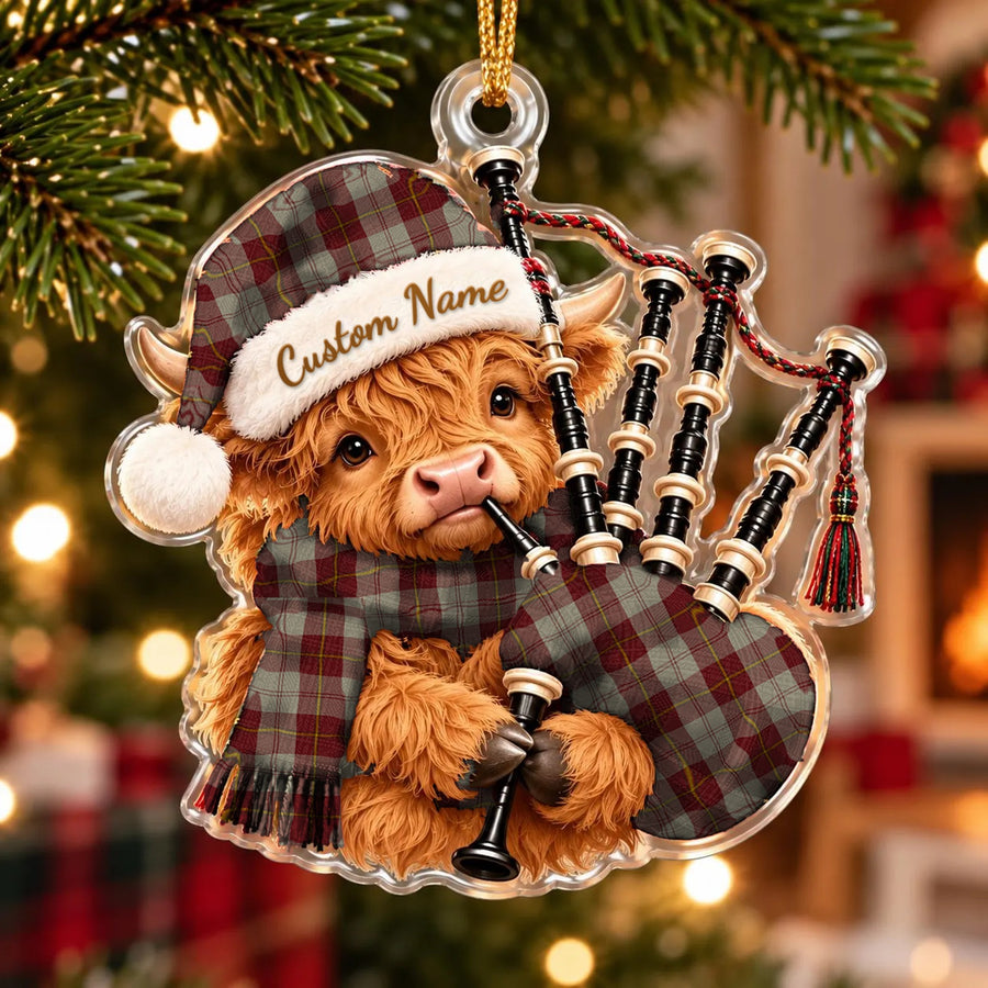 Acrylic Highland cow calf ornament playing the bagpipes, in a Cunningham Burgundy Dancers tartan Santa hat, scarf and pipe bag, with a custom name on the hat