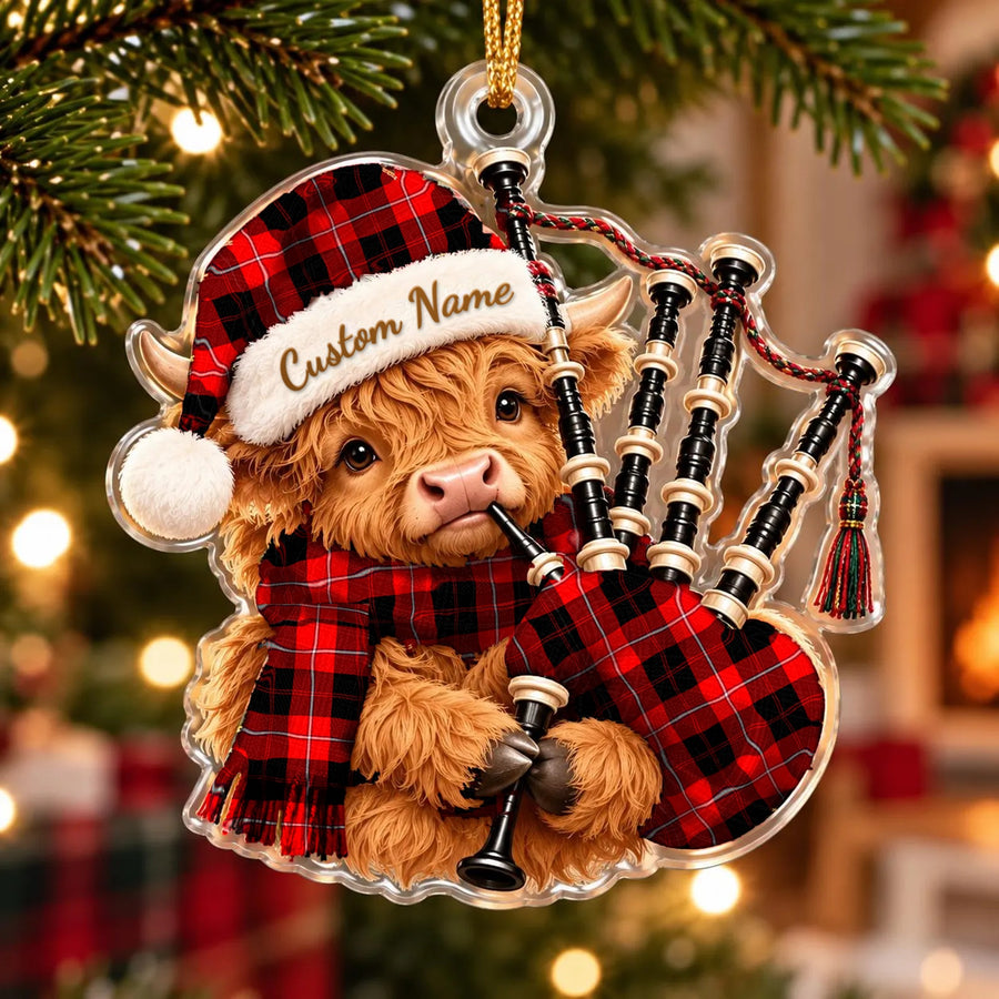 Acrylic Highland cow calf ornament playing the bagpipes, in a Cunningham Modern tartan Santa hat, scarf and pipe bag, with a custom name on the hat