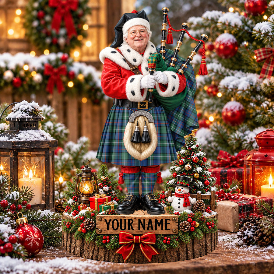 Personalized Christmas piper plaque in the Davidson of Tulloch tartan, standing on a snowy log base with a name plaque