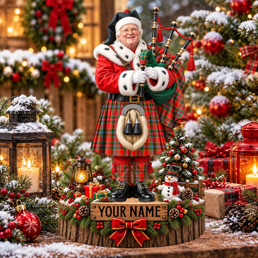 Personalized Christmas piper plaque in the Drummond of Perth tartan, standing on a snowy log base with a name plaque