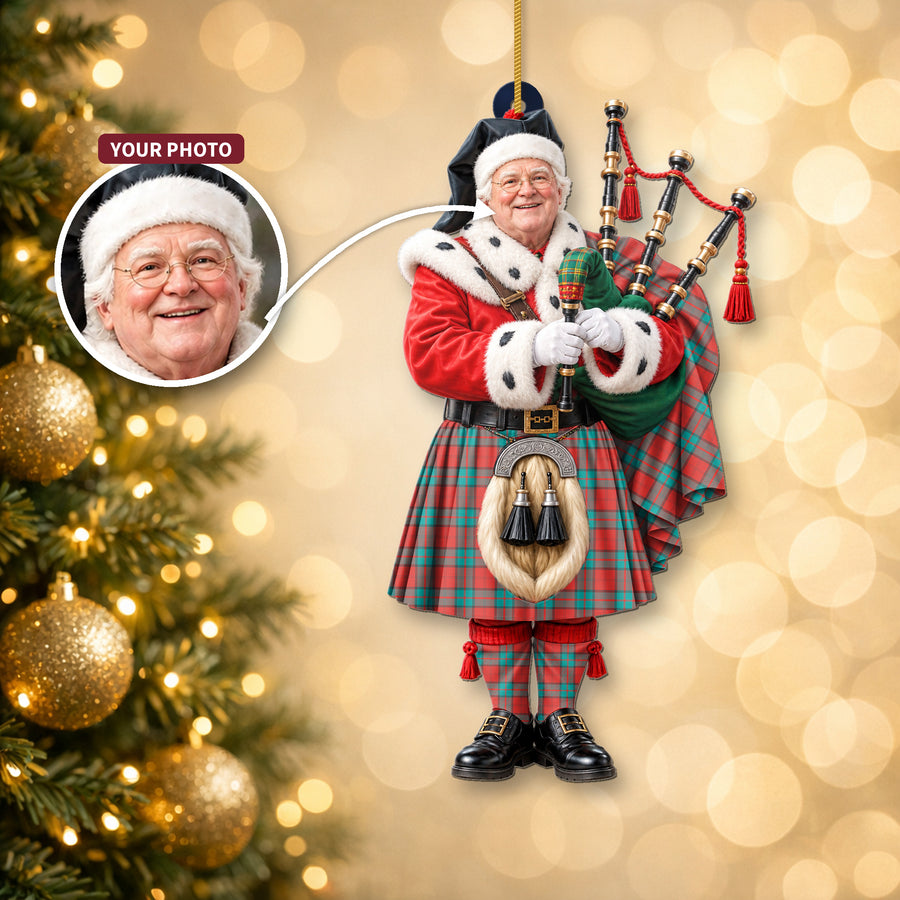 Christmas piper ornament in the Dunbar Ancient tartan hanging on a Christmas tree, with the customer photo used for the face