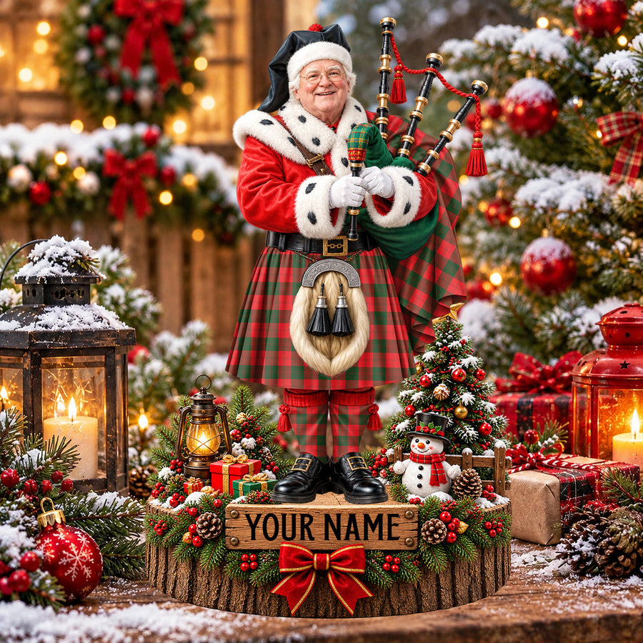 Personalized Christmas piper plaque in the Erskine Modern tartan, standing on a snowy log base with a name plaque