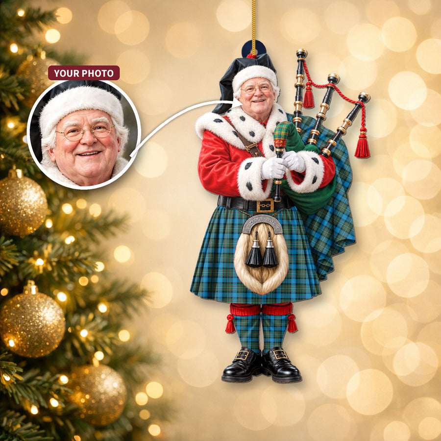 Christmas piper ornament in the Fergusson Ancient tartan hanging on a Christmas tree, with the customer photo used for the face