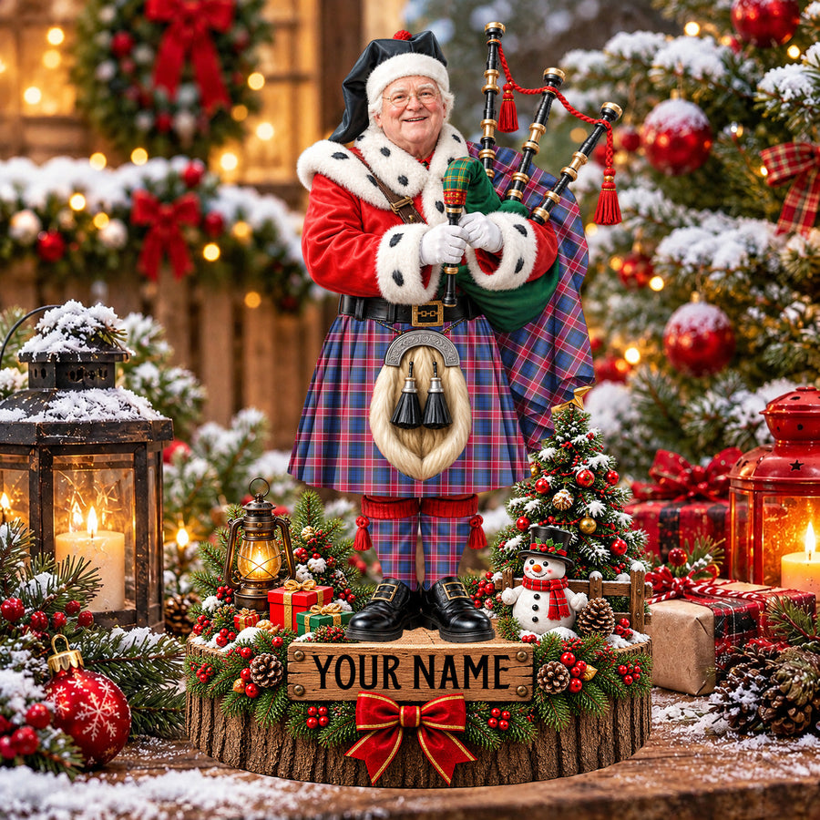 Personalized Christmas piper plaque in the Graham of Menteith Red tartan, standing on a snowy log base with a name plaque