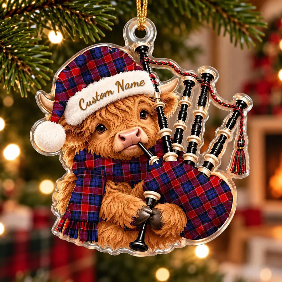 Acrylic Highland cow calf ornament playing the bagpipes, in a Haldane 1 tartan Santa hat, scarf and pipe bag, with a custom name on the hat