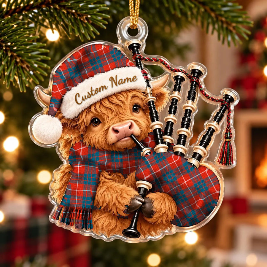 Acrylic Highland cow calf ornament playing the bagpipes, in a Hamilton Ancient tartan Santa hat, scarf and pipe bag, with a custom name on the hat