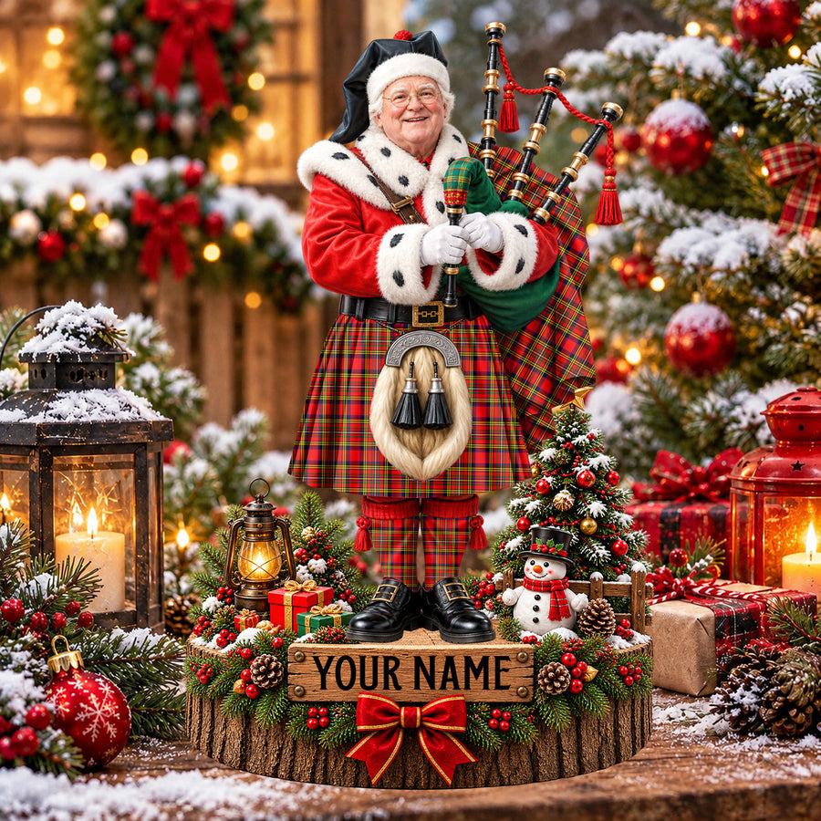 Personalized Christmas piper plaque in the Hepburn tartan, standing on a snowy log base with a name plaque