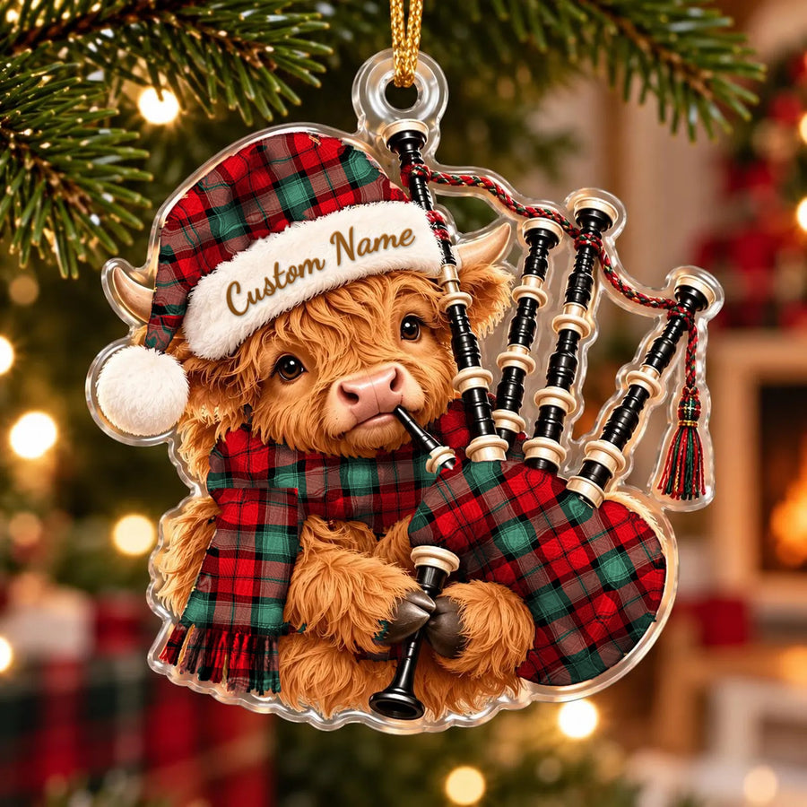 Acrylic Highland cow calf ornament playing the bagpipes, in a Kerr Ancient tartan Santa hat, scarf and pipe bag, with a custom name on the hat