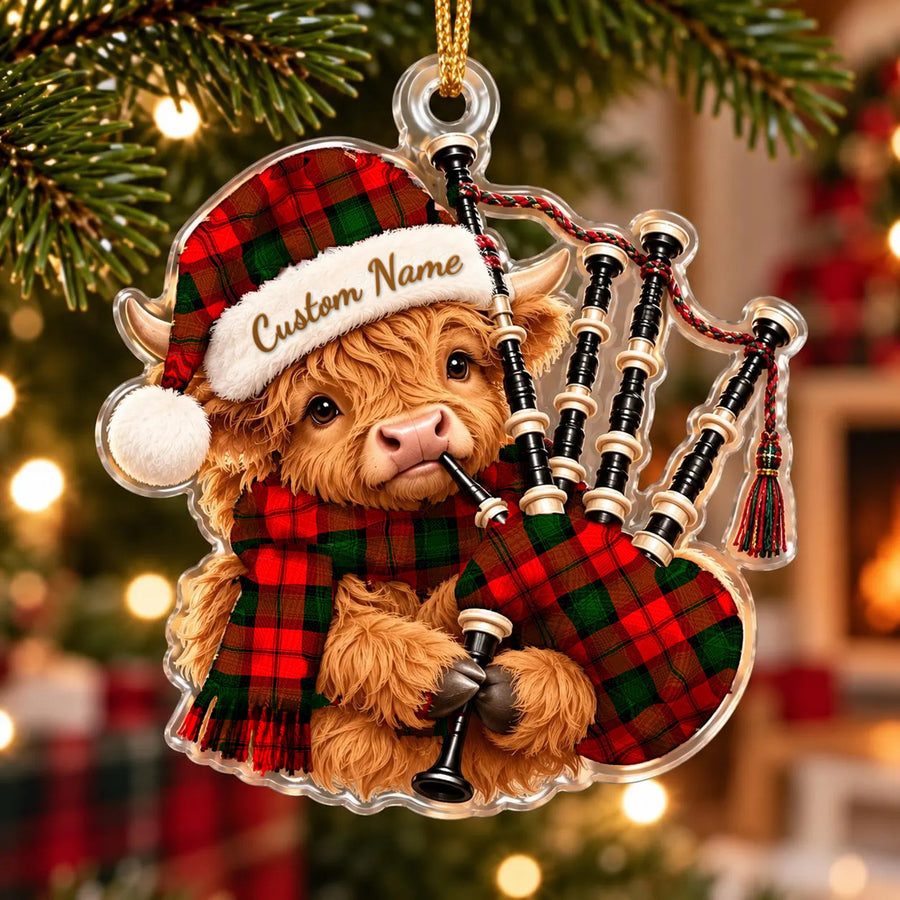 Acrylic Highland cow calf ornament playing the bagpipes, in a Kerr Modern tartan Santa hat, scarf and pipe bag, with a custom name on the hat
