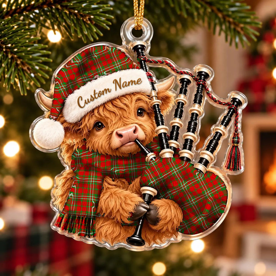 Acrylic Highland cow calf ornament playing the bagpipes, in a Langlands tartan Santa hat, scarf and pipe bag, with a custom name on the hat