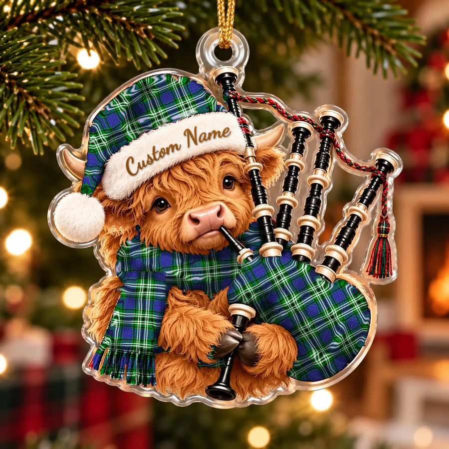 Acrylic Highland cow calf ornament playing the bagpipes, in a Learmonth tartan Santa hat, scarf and pipe bag, with a custom name on the hat