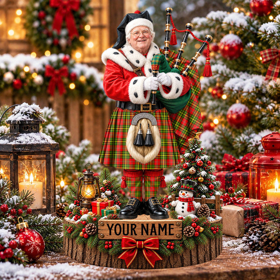 Personalized Christmas piper plaque in the Leask tartan, standing on a snowy log base with a name plaque