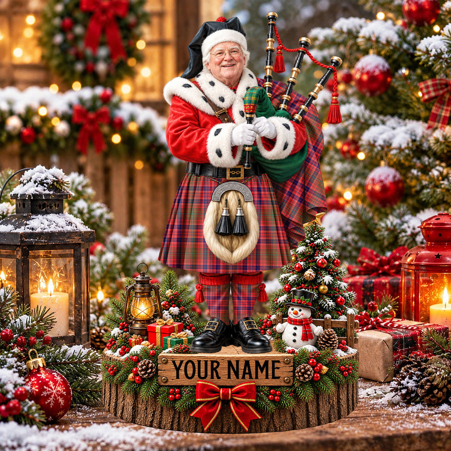 Personalized Christmas piper plaque in the Lumsden Modern tartan, standing on a snowy log base with a name plaque