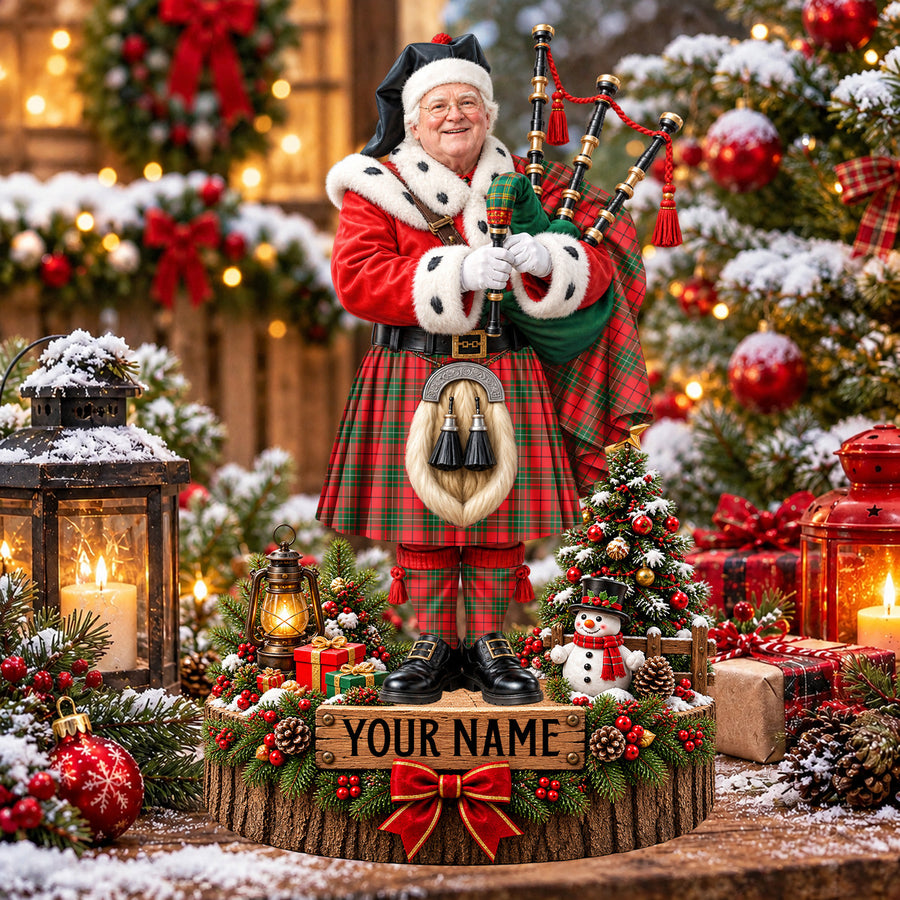 Personalized Christmas piper plaque in the MacAulay Modern tartan, standing on a snowy log base with a name plaque