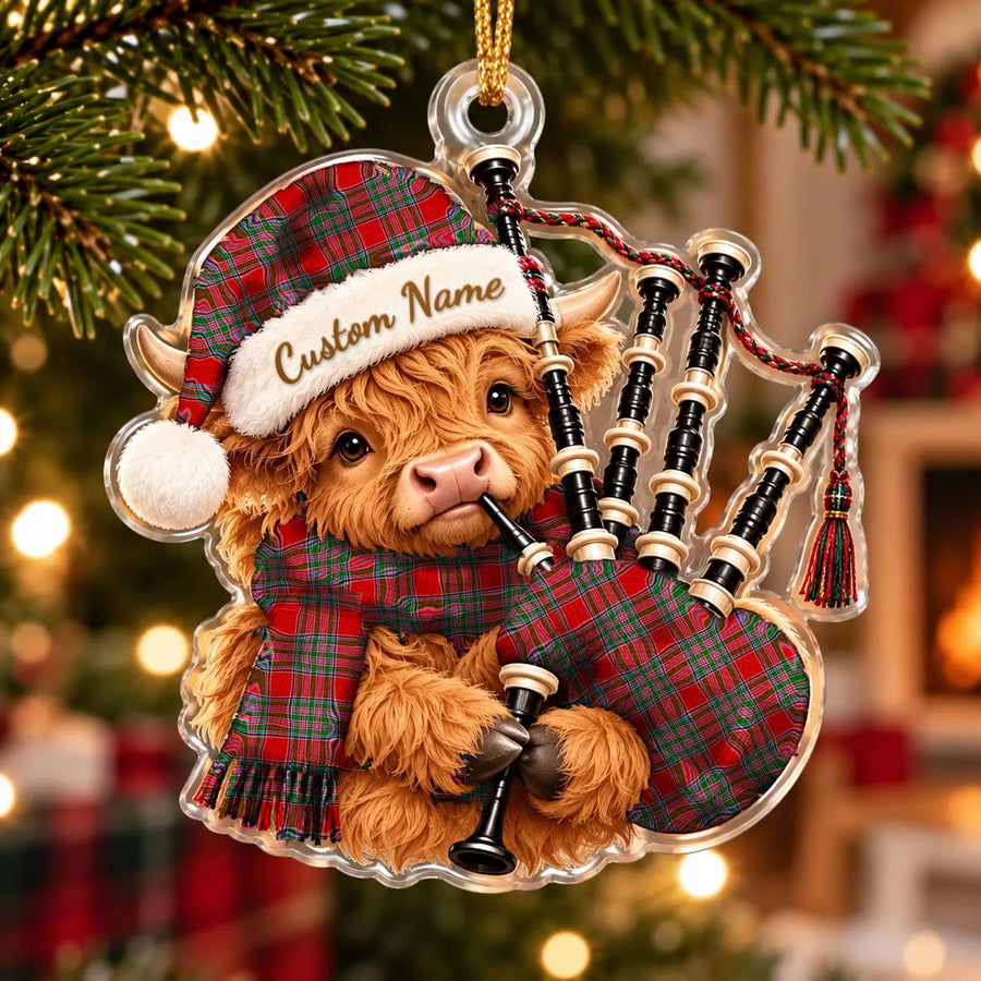 Acrylic Highland cow calf ornament playing the bagpipes, in a MacBain tartan Santa hat, scarf and pipe bag, with a custom name on the hat