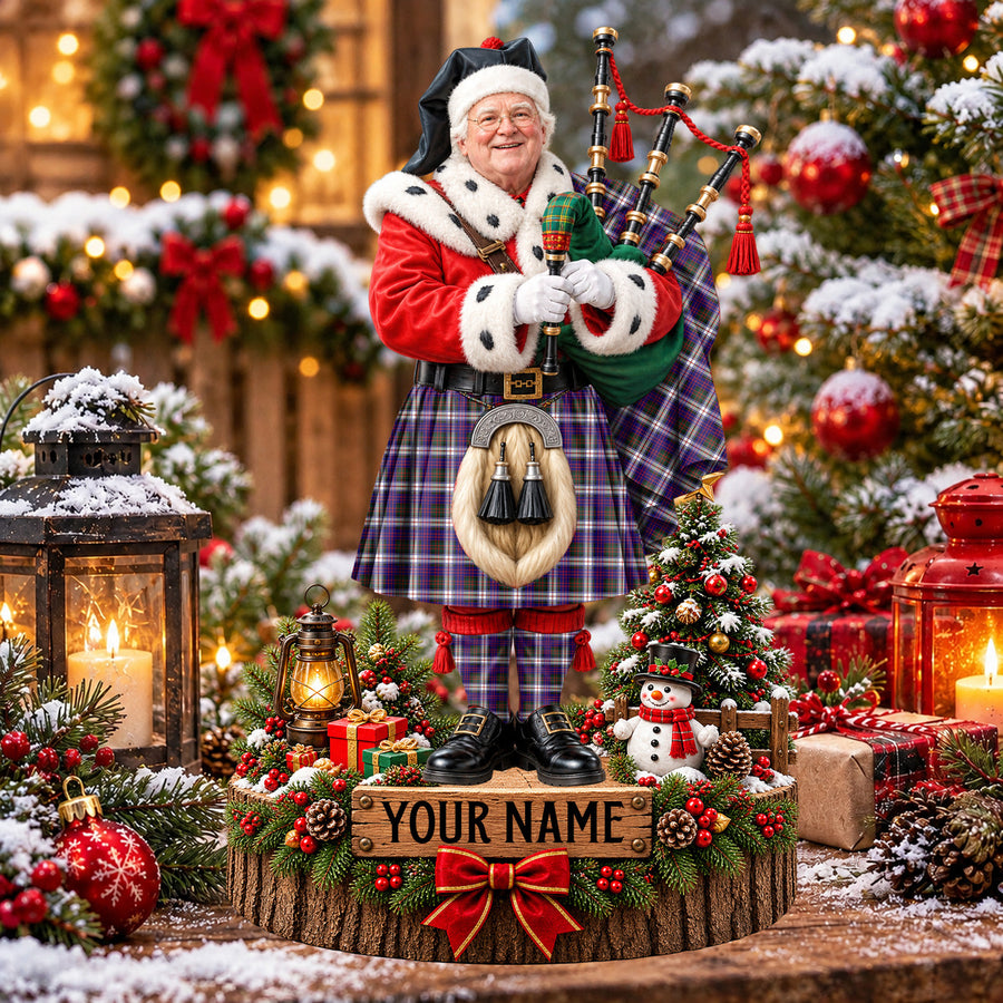 Personalized Christmas piper plaque in the MacDonald Dress Modern tartan, standing on a snowy log base with a name plaque