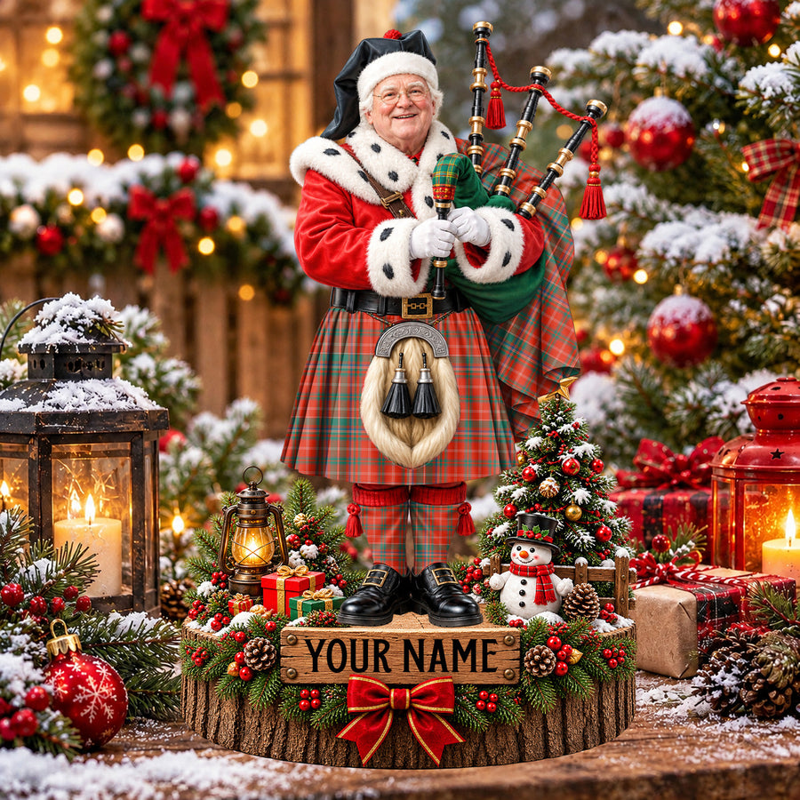Personalized Christmas piper plaque in the MacDougall Ancient tartan, standing on a snowy log base with a name plaque