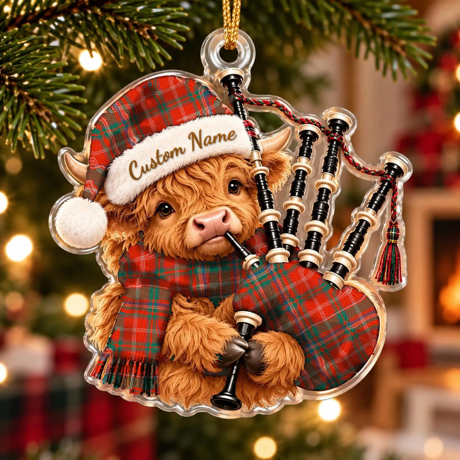 Acrylic Highland cow calf ornament playing the bagpipes, in a MacDougall Ancient tartan Santa hat, scarf and pipe bag, with a custom name on the hat