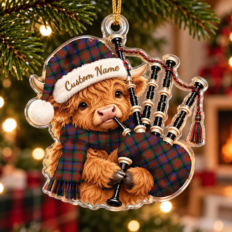 Acrylic Highland cow calf ornament playing the bagpipes, in a MacDuff Hunting Modern tartan Santa hat, scarf and pipe bag, with a custom name on the hat