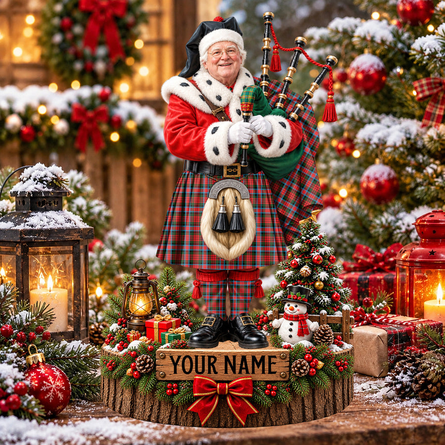 Personalized Christmas piper plaque in the MacDuff Modern tartan, standing on a snowy log base with a name plaque
