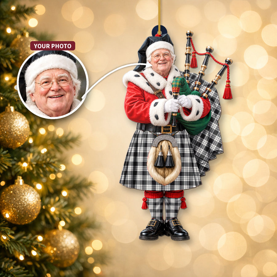 Christmas piper ornament in the MacFarlane Black & White Ancient tartan hanging on a Christmas tree, with the customer photo used for the face