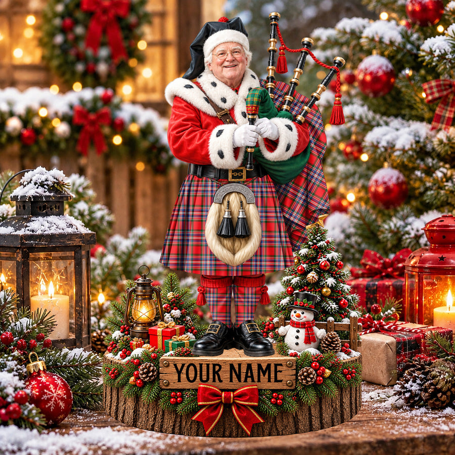 Personalized Christmas piper plaque in the MacFarlane Modern tartan, standing on a snowy log base with a name plaque