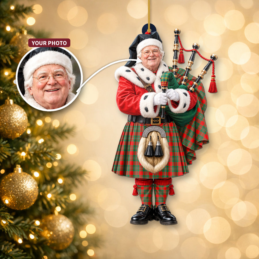 Christmas piper ornament in the MacGregor Ancient tartan hanging on a Christmas tree, with the customer photo used for the face