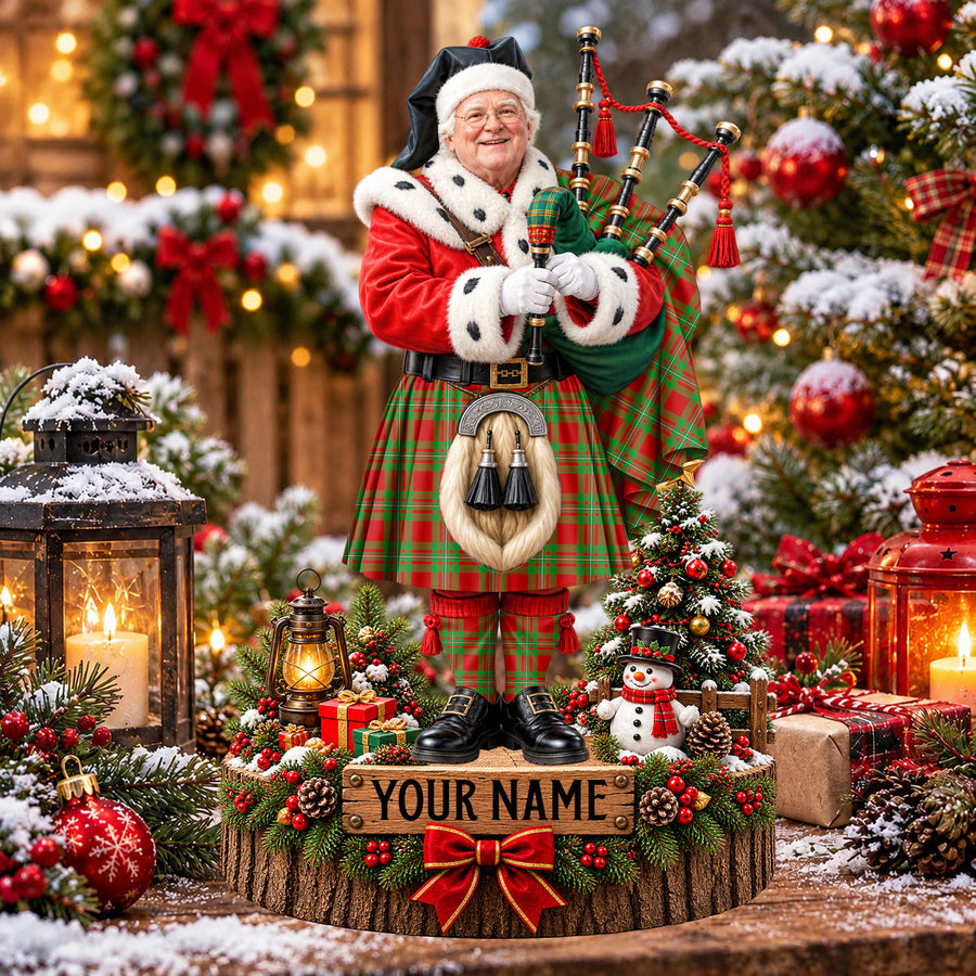 Personalized Christmas piper plaque in the MacGregor Modern tartan, standing on a snowy log base with a name plaque