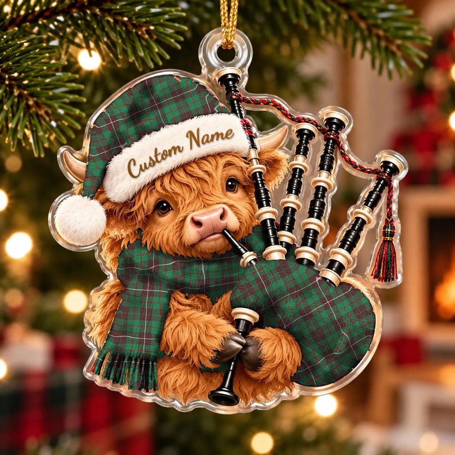 Acrylic Highland cow calf ornament playing the bagpipes, in a MacKinnon Hunting Ancient tartan Santa hat, scarf and pipe bag, with a custom name on the hat