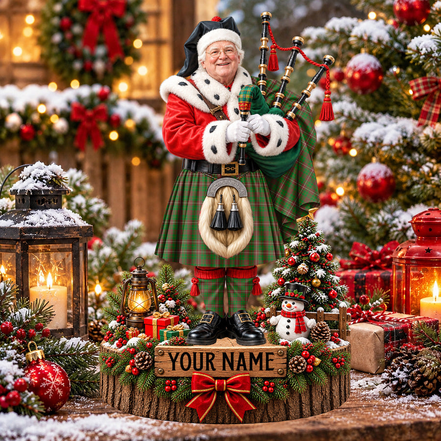 Personalized Christmas piper plaque in the MacKinnon Hunting Modern tartan, standing on a snowy log base with a name plaque