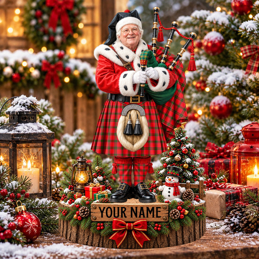 Personalized Christmas piper plaque in the MacNab Modern tartan, standing on a snowy log base with a name plaque