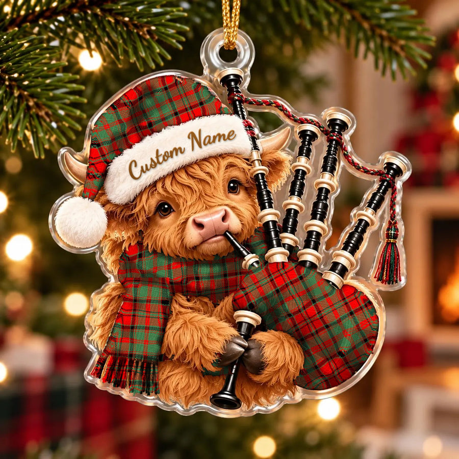 Acrylic Highland cow calf ornament playing the bagpipes, in a Macnish Modern tartan Santa hat, scarf and pipe bag, with a custom name on the hat
