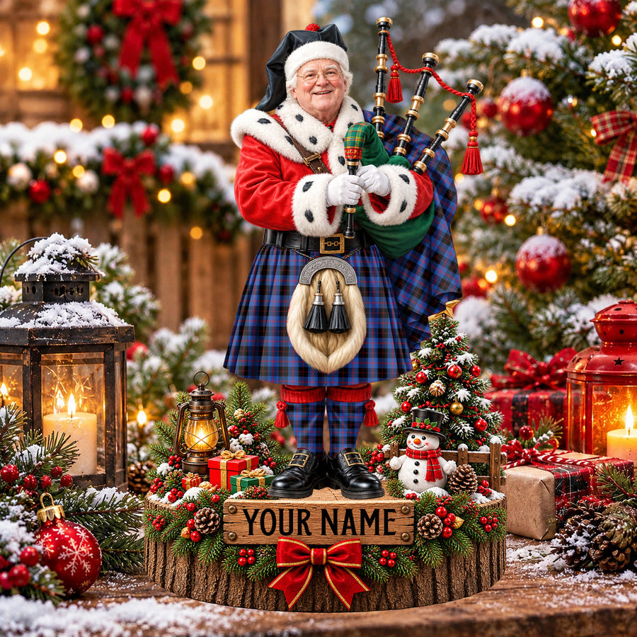Personalized Christmas piper plaque in the Maule tartan, standing on a snowy log base with a name plaque