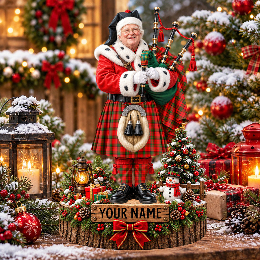 Personalized Christmas piper plaque in the Maxwell Modern tartan, standing on a snowy log base with a name plaque