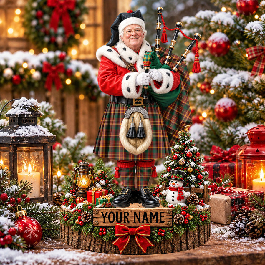 Personalized Christmas piper plaque in the McNally tartan, standing on a snowy log base with a name plaque